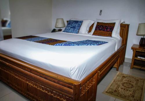 a large wooden bed in a room with at CONGRESS HOTEL Yaoundé in Yaoundé