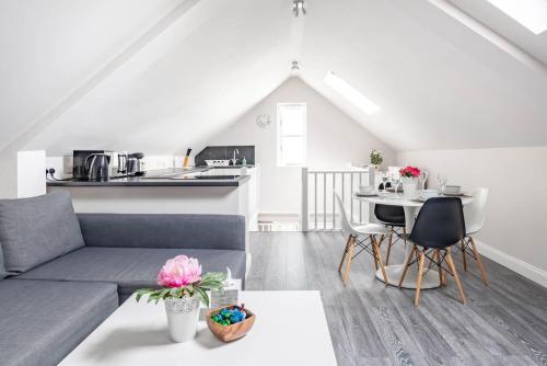 a living room with a couch and a table at Bright, Restful Coach House in Central Sevenoaks in Sevenoaks