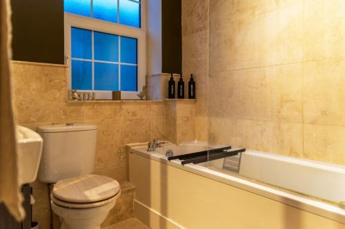 a bathroom with a toilet and a sink and a tub at Cosy Days Cottage in Skipton