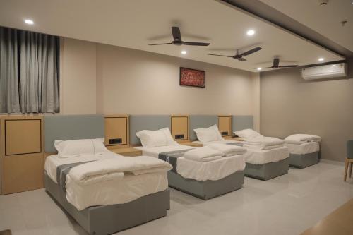 a room with four beds in a room at The Aeran Foods & Hospitality in Chhala