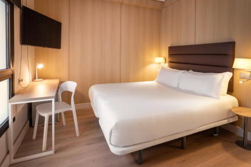 a hotel room with a large bed and a desk at B&B HOTEL Vitoria General Álava in Vitoria-Gasteiz