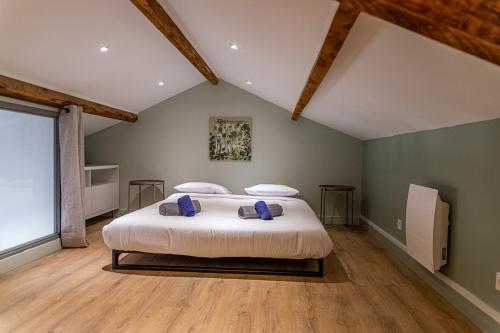 une chambre avec un grand lit blanc avec des oreillers bleus dans l'établissement T4 d'exception à Aix, à Aix-en-Provence