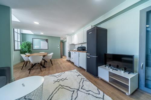 Il comprend une cuisine et une salle à manger avec une table et une télévision. dans l'établissement T4 d'exception à Aix, à Aix-en-Provence