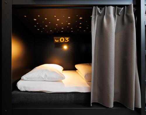 a bed in a room with a sign on the wall at Little Monkey Hostel in Enschede