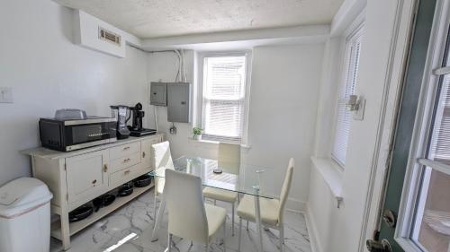 a small white room with a table and a microwave at Rooftop GreeneHouse Suite in Philadelphia