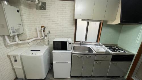 a small kitchen with a sink and a stove at 1階 2025年3月オープン 小岩徒歩15分 収容4人 成田羽田からバス直通 in Tokyo