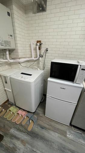 a computer and a printer and some sandals on the floor at 1階 2025年3月オープン 小岩徒歩15分 収容4人 成田羽田からバス直通 in Tokyo