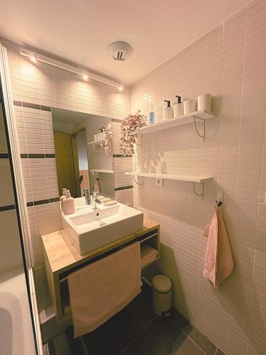 une salle de bain avec un lavabo et un miroir dans l'établissement Parenthèse Blanche - Au pied des pistes Paradiski, à La Plagne Tarentaise