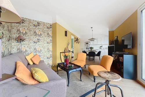 - un salon avec un canapé gris et des fauteuils orange dans l'établissement Superb apartment with large terrace, à Paris