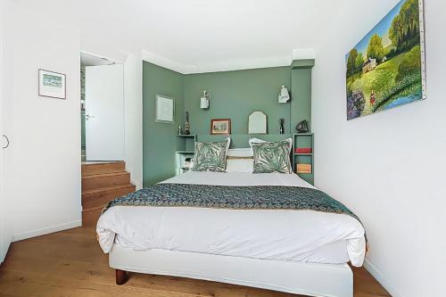 - une chambre avec un grand lit et des murs verts dans l'établissement Superb apartment with large terrace, à Paris