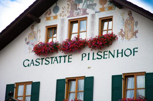 a building with flowers on the side of it at Landgasthof Pilsenhof Entenbraterei in Hechendorf am Pilsensee