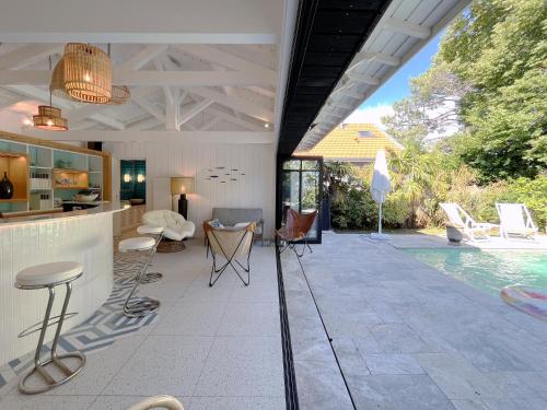 un patio avec un bar et une piscine dans l'établissement La Villa Cissia , sur la plage, à Andernos-les-Bains