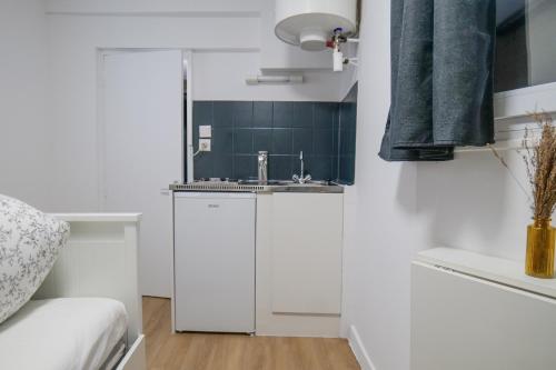 a kitchen with white cabinets and a sink at charmante studette - 2 personnes - La Doutre in Angers