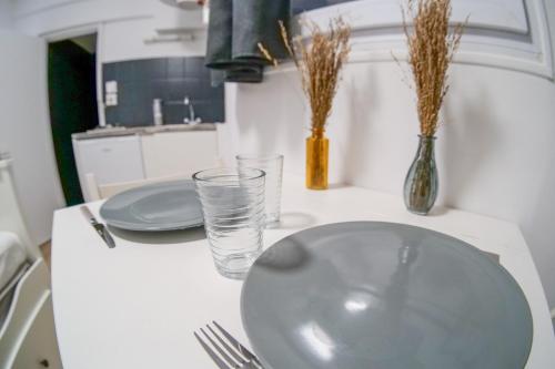 a white table with a plate and glasses on it at charmante studette - 2 personnes - La Doutre in Angers