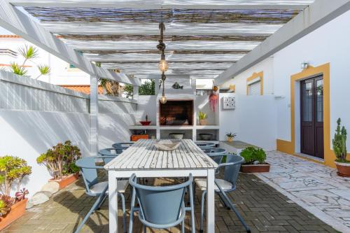 an outdoor patio with a table and chairs at CASA DO TANQUE AMARELO by Stay in Alentejo in Vila Nova de Milfontes