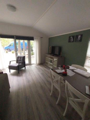 a living room with a table and chairs in a room at Bos Chalet Huize Vriendschap in Hattemerbroek