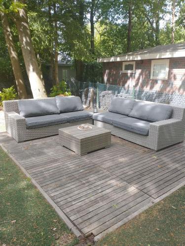 two couches sitting on top of a wooden deck at Bos Chalet Huize Vriendschap in Hattemerbroek
