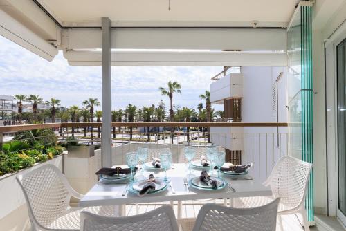 a white table and chairs on a balcony at UHC Formentor Apartments in Salou