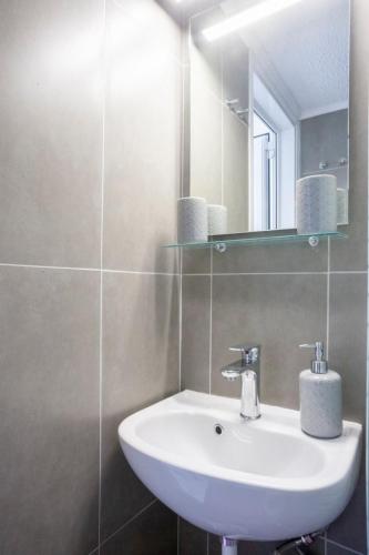 a bathroom with a white sink and a mirror at Big blue pefkohori in Pefkohori