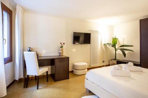 a hotel room with a bed and a desk and a chair at Luxury Apartment in San Marco, Venice in Venice