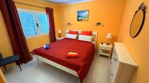 a bedroom with a bed with red sheets and a mirror at App 308 - Wundervoller Meerblick, sehr zentrale Lage, angenehm ruhig in Tías