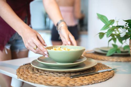 a person preparing a bowl of food on a table at Nura Houses Magaluf Beach in Magaluf