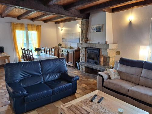 un salon avec un canapé et une cheminée dans l'établissement Charmante Demeure bretonne, à Plouëc