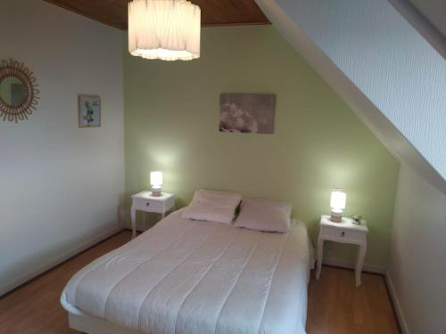 une chambre avec un lit blanc avec deux tables de nuit dans l'établissement Charmante Demeure bretonne, à Plouëc