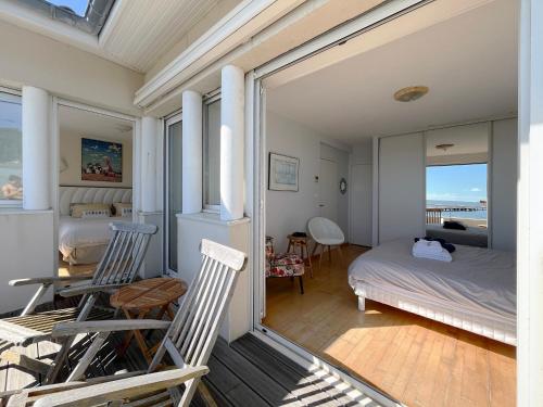 - une chambre avec deux chaises, un lit et une table dans l'établissement La Villa Cissia , sur la plage, à Andernos-les-Bains