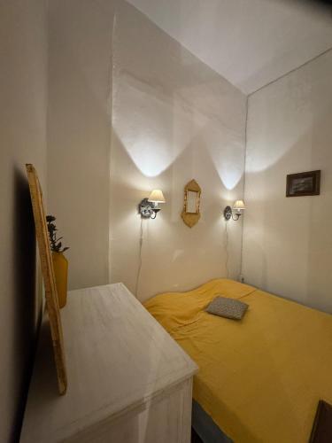 a small bedroom with a yellow bed with two lights at Mirador de la médina in Tunis