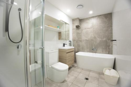 a bathroom with a toilet and a sink and a shower at KozyGuru | Epping | Stylish 1 Bedroom Apartment in Epping