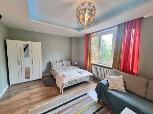 a small bedroom with a bed and a couch at Studio Orzeł Biały in Bytom