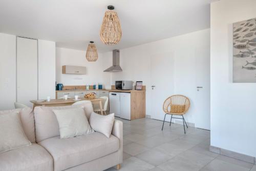un salon avec un canapé et une cuisine dans l'établissement Bel appartement pour 6, vue mer, 50m plage, à Pléneuf-Val-André