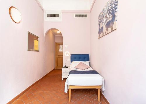 a small room with a bed and a mirror at Hotel Costantini in Florence