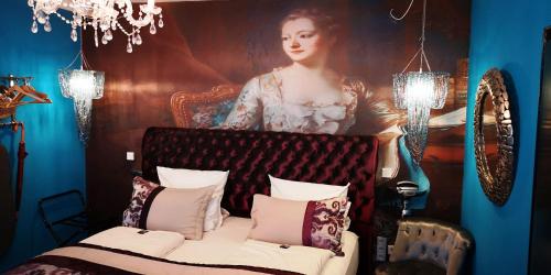 a bedroom with a portrait of a woman behind a bed at Boutique Hotel & Bio Wirtshaus Schwarzer Bock in Ansbach