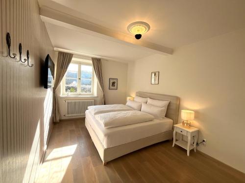 a white bedroom with a bed and a window at KAROLINGERHOF - Mosel in Kröv