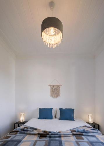 a bedroom with a bed and a chandelier at Casa Chaouen in Mouronho