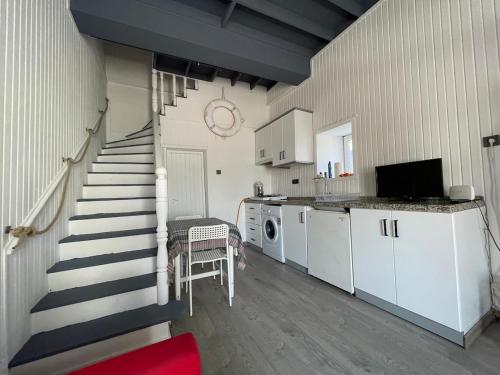 a room with a staircase and a kitchen with at Cozy Stone house in the Bozcaada center in Bozcaada