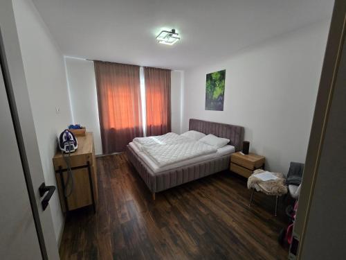 a bedroom with a bed and a wooden floor at Apartman Velka Lomnica Lesna 5 in Veľká Lomnica