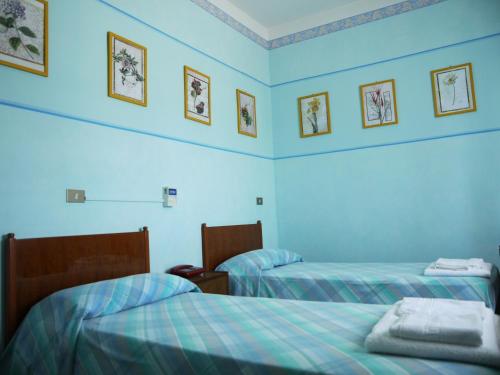 2 letti in una camera con pareti blu di Pensione Lidia a San Salvo