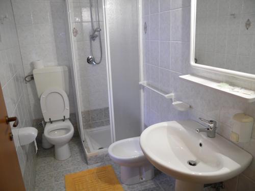 a white bathroom with a toilet and a sink at Pensione Lidia in San Salvo