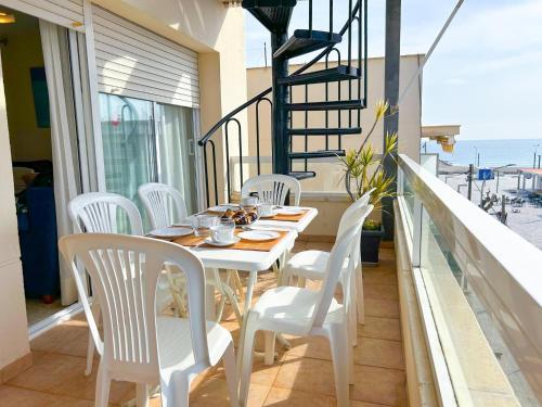 a white table and chairs on a balcony with the ocean at Apartment Rivel in Cubelles