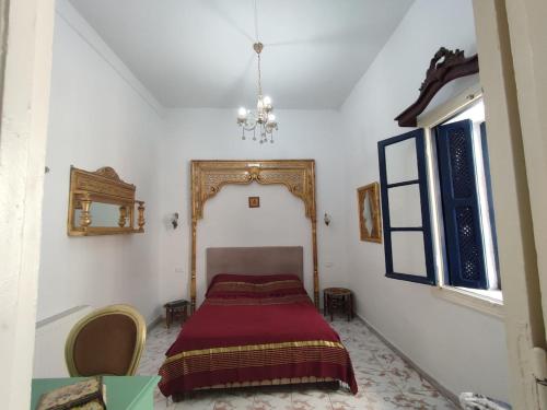 a bedroom with a bed with a red blanket at Maison jaune médina de Tunis in Tunis