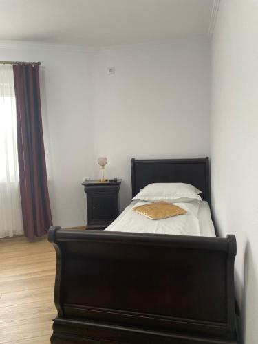 a bedroom with a bed with a black bed frame at Vila Miorita in Sebeş