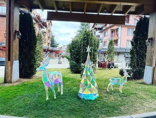 three sculptures of giraffes and a christmas tree at Pirin Golf View Apartment Bansko in Bansko