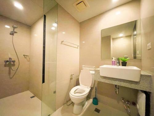 ein Badezimmer mit Toilette, Waschbecken und Dusche in der Unterkunft Prime BGC 1BR Near Mitsukoshi Mall #upt16m in Manila