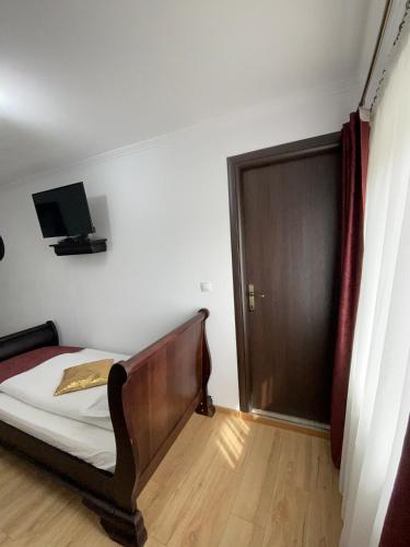 a bedroom with a bed and a door with a television at Vila Miorita in Sebeş