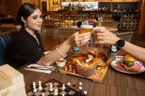 two people sitting at a table with food and drinks at Four Points by Sheraton Cancun Centro in Cancún