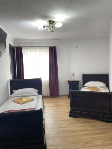 a bedroom with two beds and a window at Vila Miorita in Sebeş
