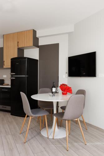 a kitchen with a table and chairs and a refrigerator at Vivian's Central Loft in Ioannina